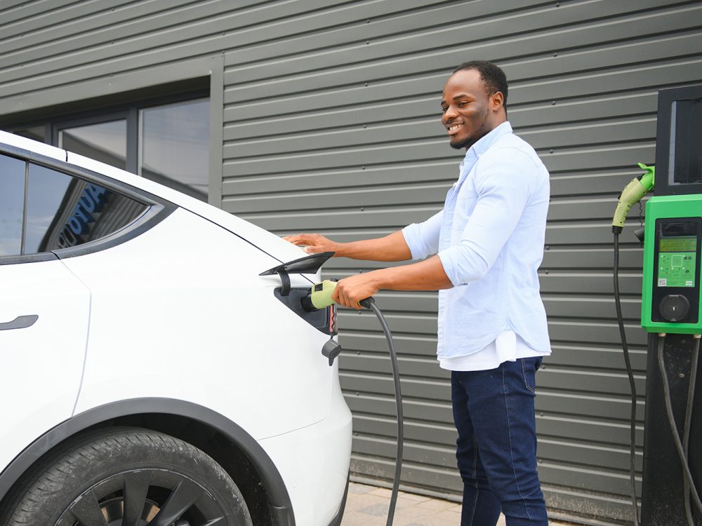 African American man charging his electric car